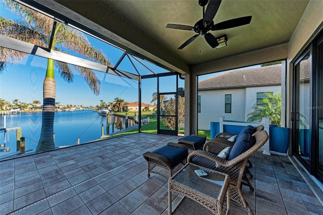 view of patio / terrace featuring glass enclosure, ceiling fan, a dock, and a water view