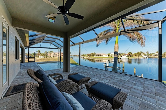 view of patio / terrace featuring glass enclosure, ceiling fan, a water view, and a boat dock