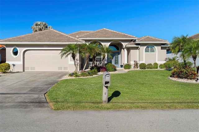 mediterranean / spanish-style home with a front yard and a garage