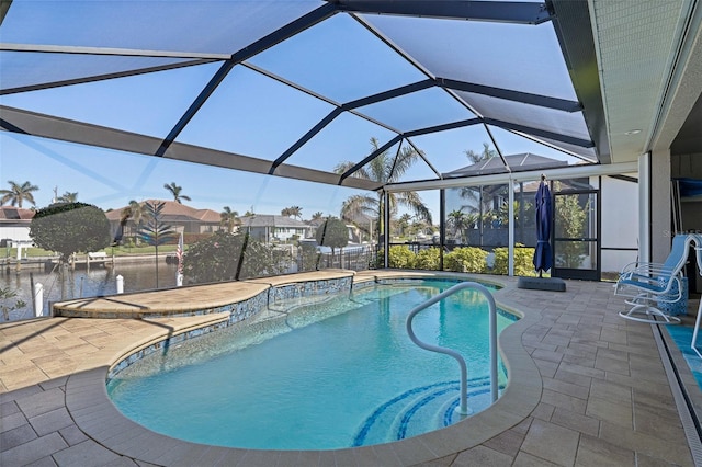 view of pool with a water view, glass enclosure, and a patio area