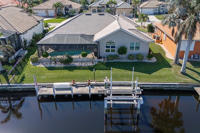 rear view of property featuring a lanai, a yard, and a water view