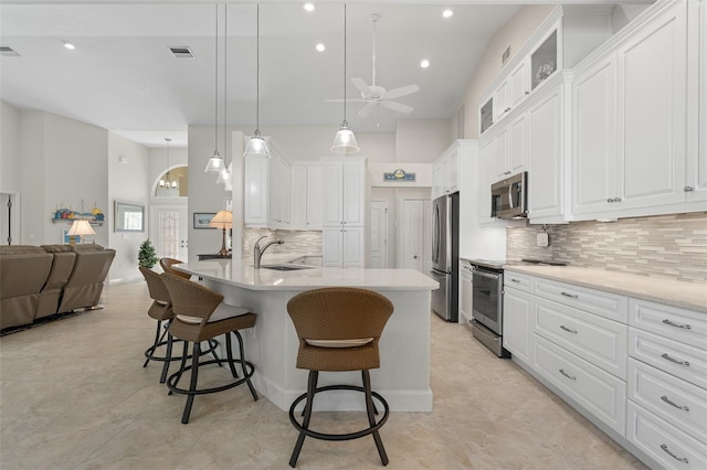 kitchen featuring appliances with stainless steel finishes, ceiling fan, sink, decorative light fixtures, and white cabinetry