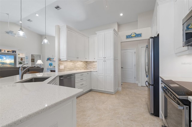 kitchen with stainless steel appliances, white cabinetry, hanging light fixtures, and sink