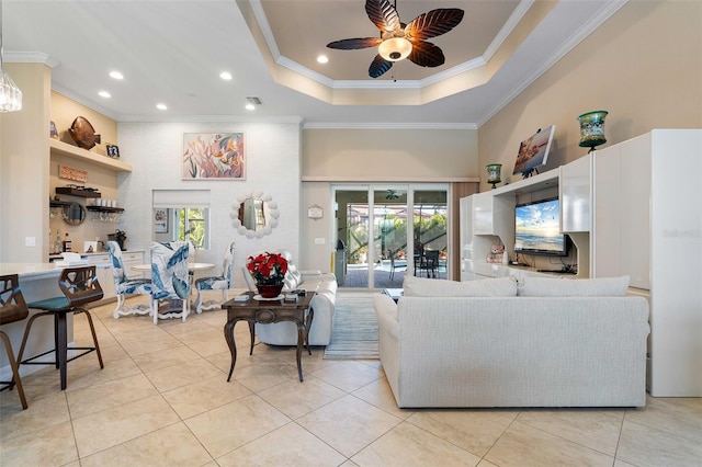 tiled living room featuring a raised ceiling, a wealth of natural light, crown molding, and ceiling fan