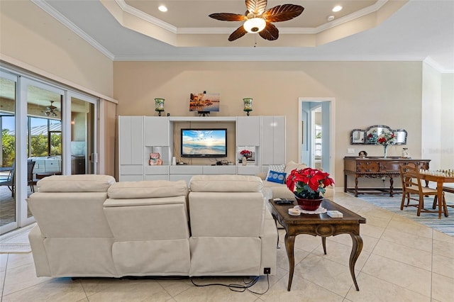 living room featuring light tile patterned floors, a raised ceiling, ceiling fan, and crown molding