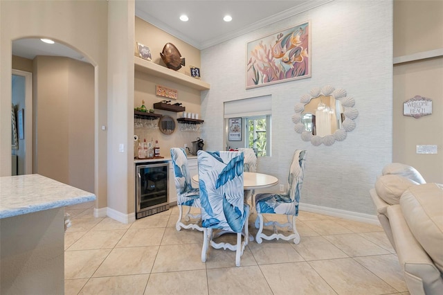 dining area featuring light tile patterned floors, indoor bar, beverage cooler, and ornamental molding