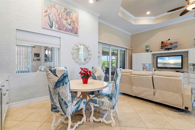 tiled dining area with ceiling fan and crown molding