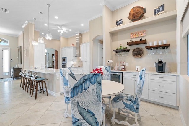 kitchen with ceiling fan, white cabinets, pendant lighting, and ornamental molding