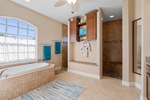 bathroom featuring plus walk in shower, tile patterned flooring, vanity, and ceiling fan