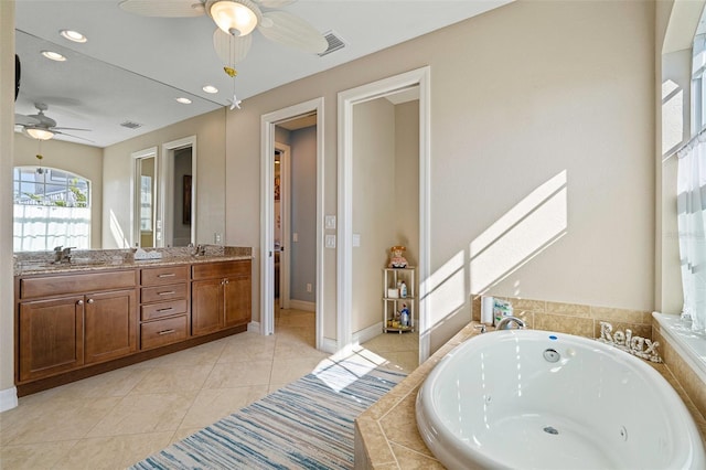 bathroom with tile patterned floors, vanity, and tiled bath