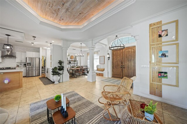 17080 Kellog Ave, Port Charlotte, FL 33954 - living area with ornate columns, a tray ceiling, arched walkways, a chandelier, and ornamental molding