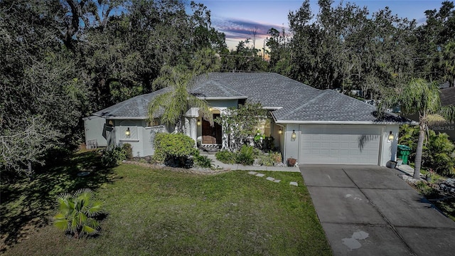 17080 Kellog Ave, Port Charlotte, FL 33954 - view of front facade with a front yard, an attached garage, driveway, roof with shingles, and stucco siding