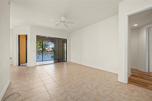 spare room with ceiling fan and light tile patterned floors