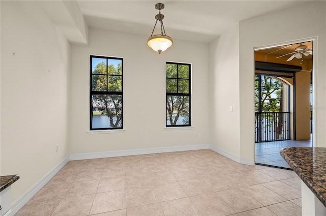 spare room with ceiling fan, plenty of natural light, and light tile patterned floors