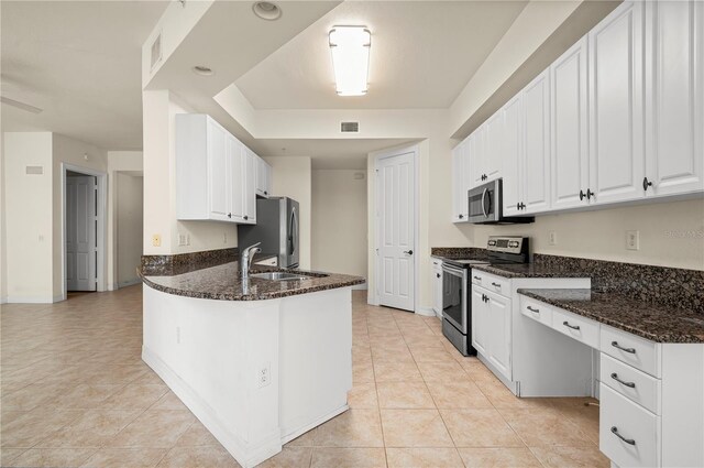 kitchen with sink, dark stone countertops, white cabinetry, and stainless steel appliances