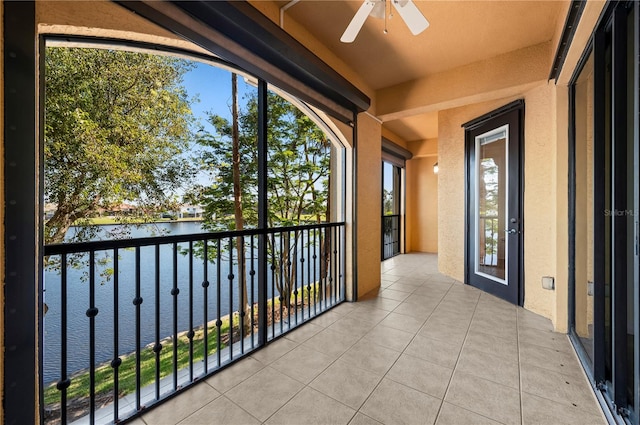 balcony featuring a water view and ceiling fan