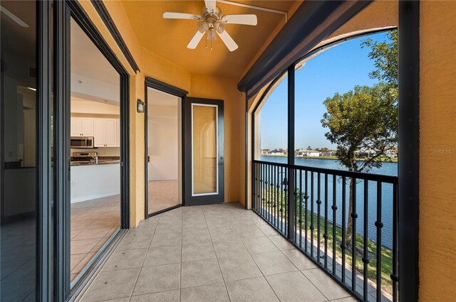 balcony with ceiling fan and a water view