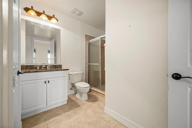 bathroom with tile patterned floors, vanity, a shower with shower door, and toilet