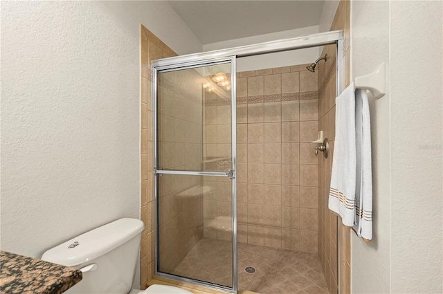 bathroom with toilet and an enclosed shower