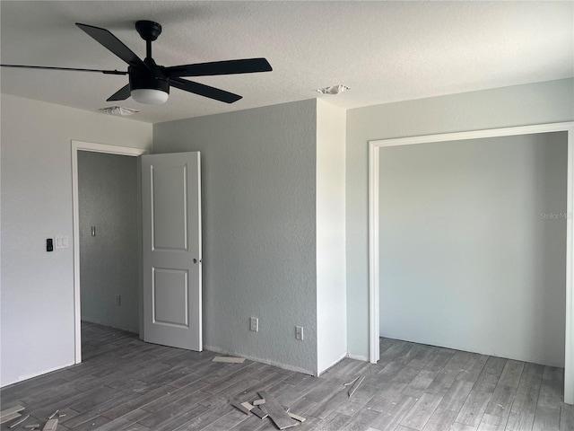 unfurnished bedroom with visible vents, a textured wall, ceiling fan, wood finished floors, and a textured ceiling