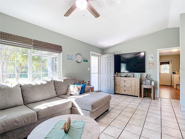 living room with lofted ceiling, ceiling fan, and light tile patterned flooring