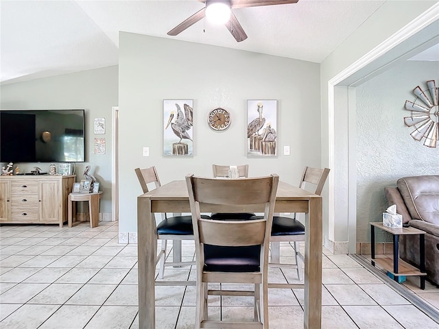 tiled dining space with vaulted ceiling and ceiling fan