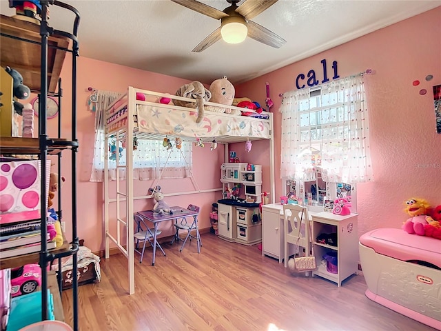 bedroom with ceiling fan, hardwood / wood-style flooring, and a textured ceiling