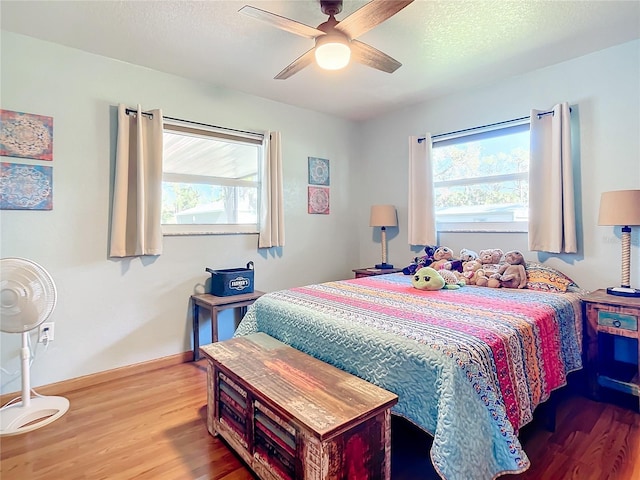 bedroom featuring wood-type flooring, multiple windows, and a textured ceiling