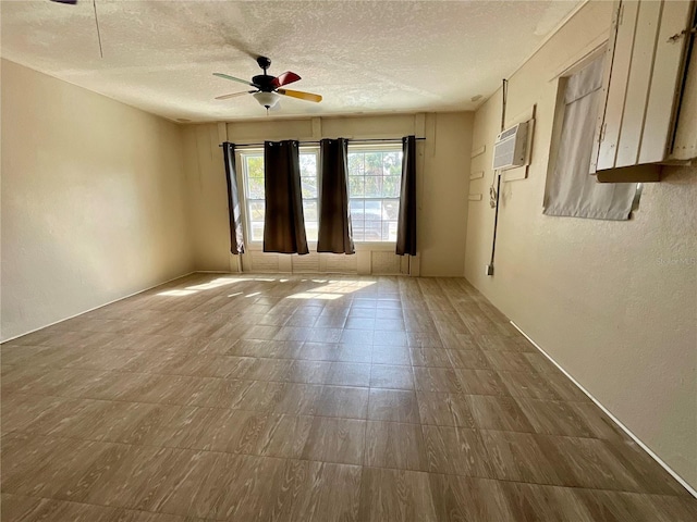 spare room featuring ceiling fan, a wall mounted air conditioner, and a textured ceiling