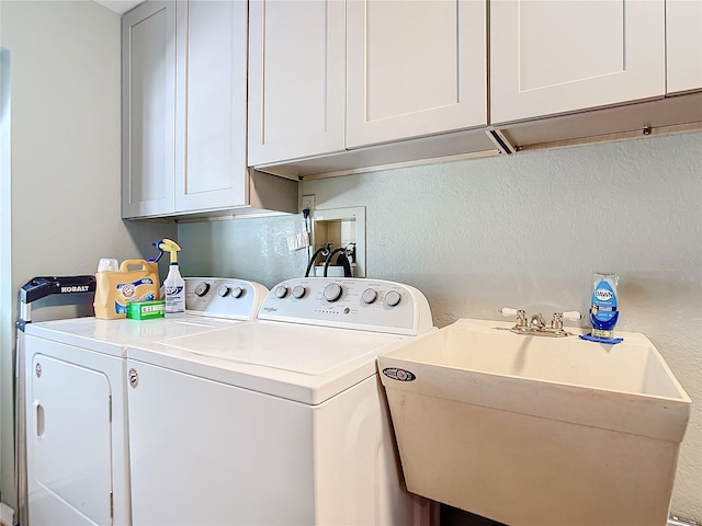 laundry room with cabinets, washing machine and dryer, and sink