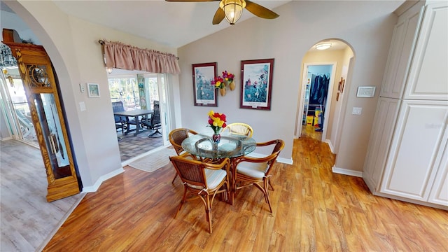 dining room featuring ceiling fan, light hardwood / wood-style floors, and vaulted ceiling