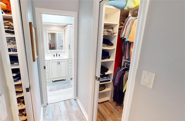 walk in closet featuring sink and light hardwood / wood-style flooring