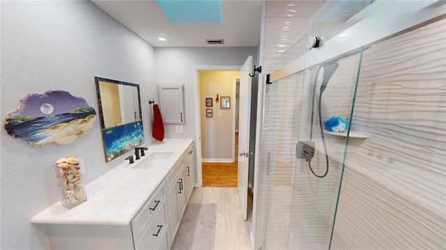 bathroom with wood-type flooring, vanity, and walk in shower