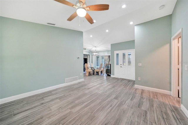 unfurnished living room with ceiling fan, high vaulted ceiling, and light hardwood / wood-style floors