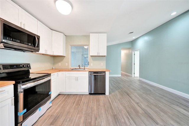 kitchen with sink, white cabinets, stainless steel appliances, and light wood-type flooring