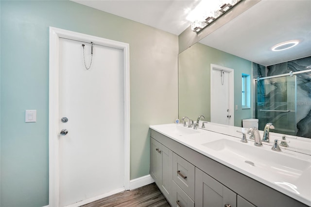 bathroom featuring an enclosed shower, vanity, toilet, and wood-type flooring