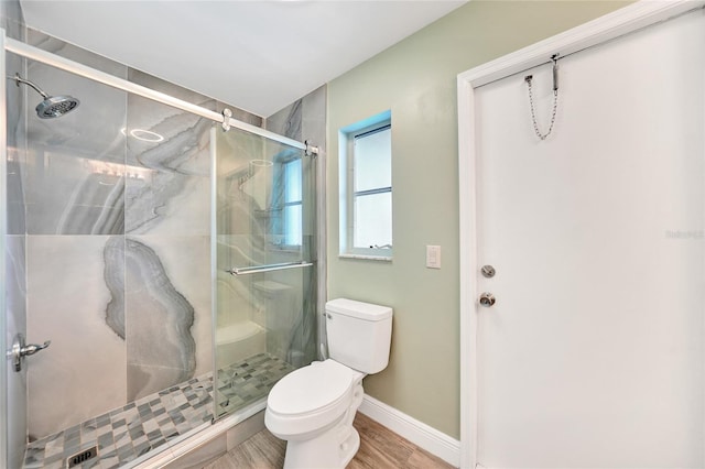 bathroom with hardwood / wood-style flooring, toilet, and an enclosed shower