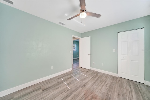 unfurnished bedroom featuring ceiling fan, light wood-type flooring, and a closet