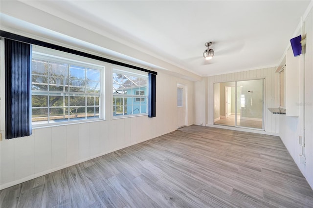 unfurnished room featuring light wood-type flooring and crown molding