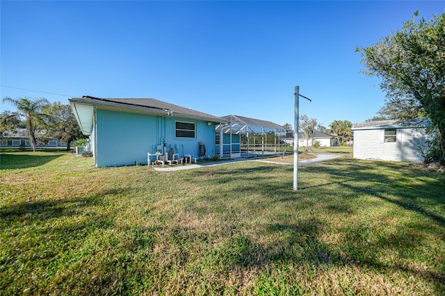 back of property featuring glass enclosure and a lawn