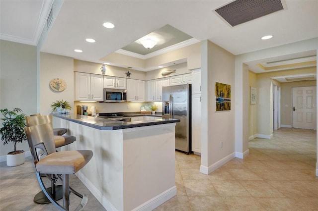 3321 Sunset Key Cir Unit 204, Punta Gorda, FL 33955 - kitchen featuring stainless steel appliances, ornamental molding, a peninsula, a breakfast bar area, and white cabinetry