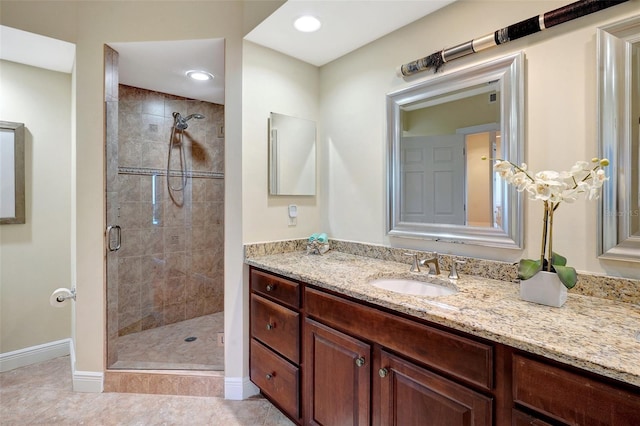 bathroom with tile patterned flooring, vanity, and a shower with door