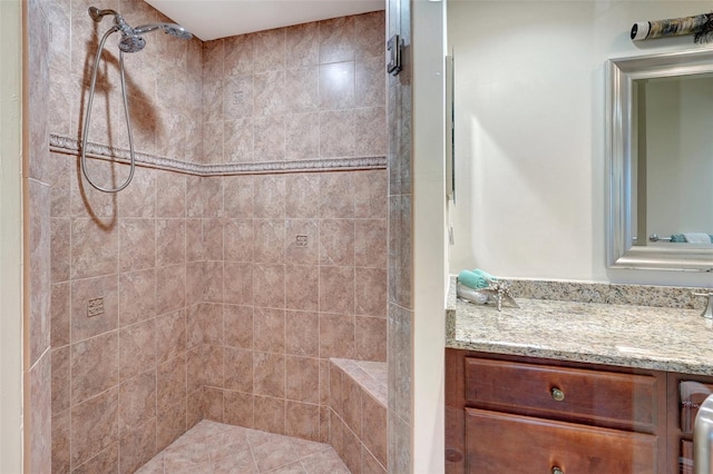 bathroom with vanity and a tile shower