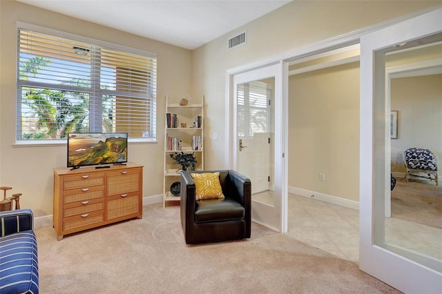 living area featuring a healthy amount of sunlight and light colored carpet