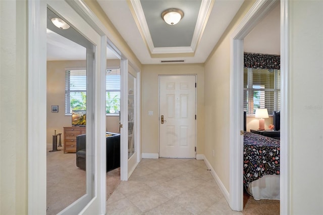 carpeted foyer with french doors, a tray ceiling, a wealth of natural light, and ornamental molding