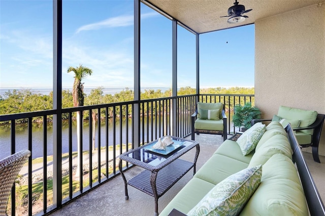 sunroom / solarium with a water view, plenty of natural light, and ceiling fan