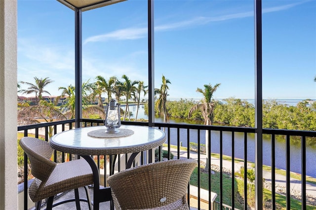 sunroom / solarium featuring a water view