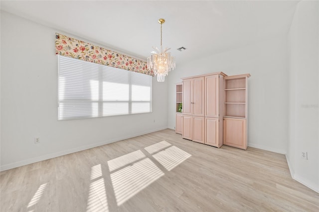 unfurnished bedroom with an inviting chandelier and light hardwood / wood-style flooring