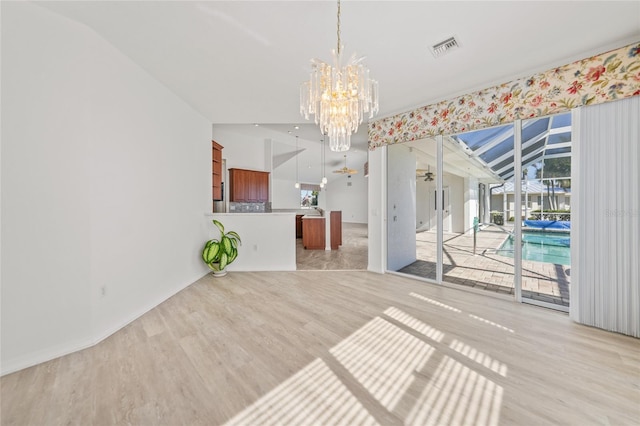 interior space featuring light hardwood / wood-style floors, lofted ceiling, and an inviting chandelier