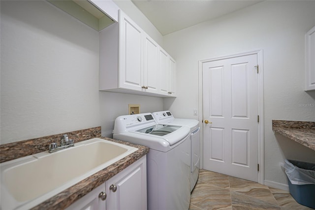 laundry area featuring cabinets, separate washer and dryer, and sink